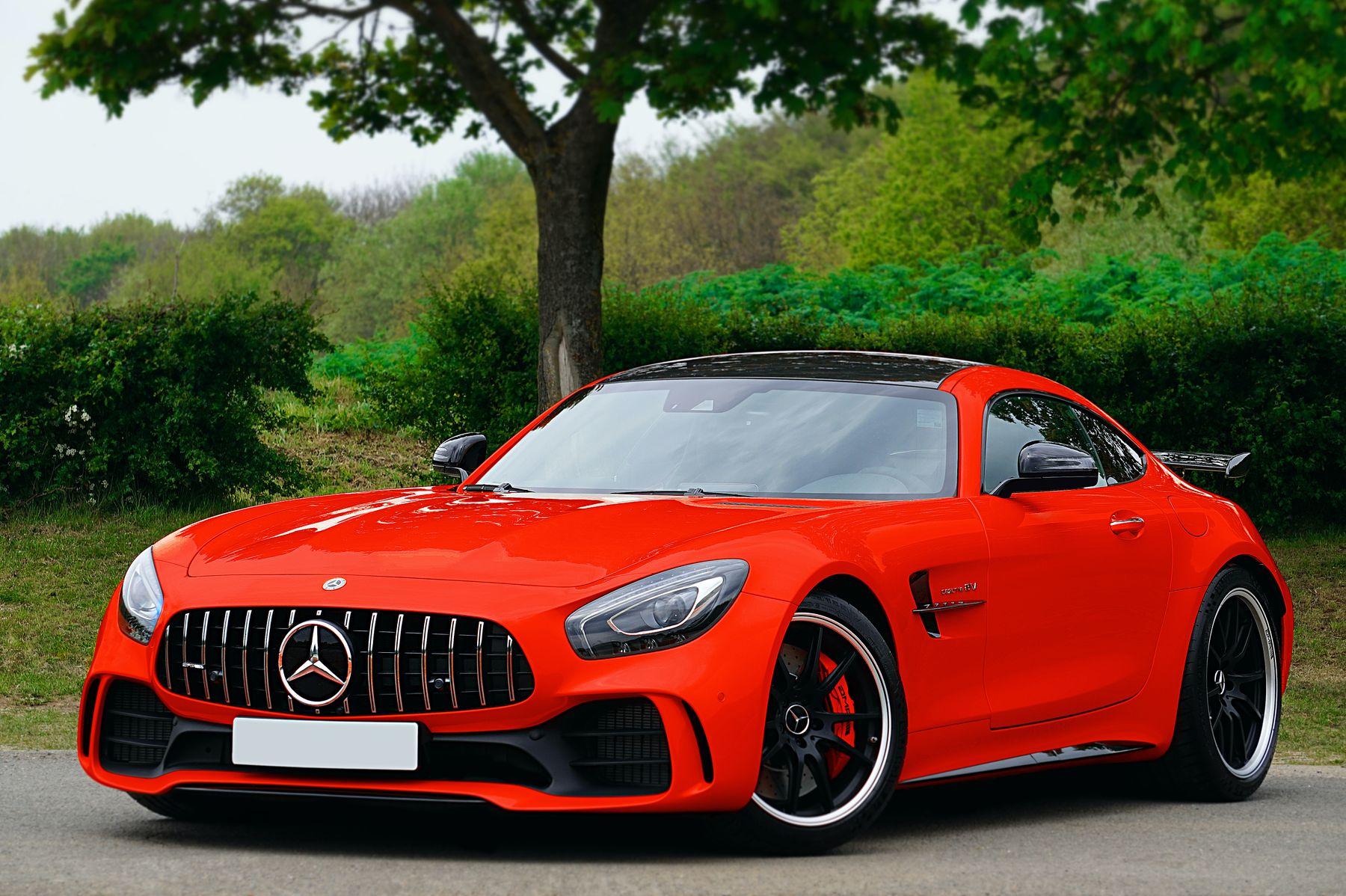 Red Mercedes-AMG GT coupe parked under a tree