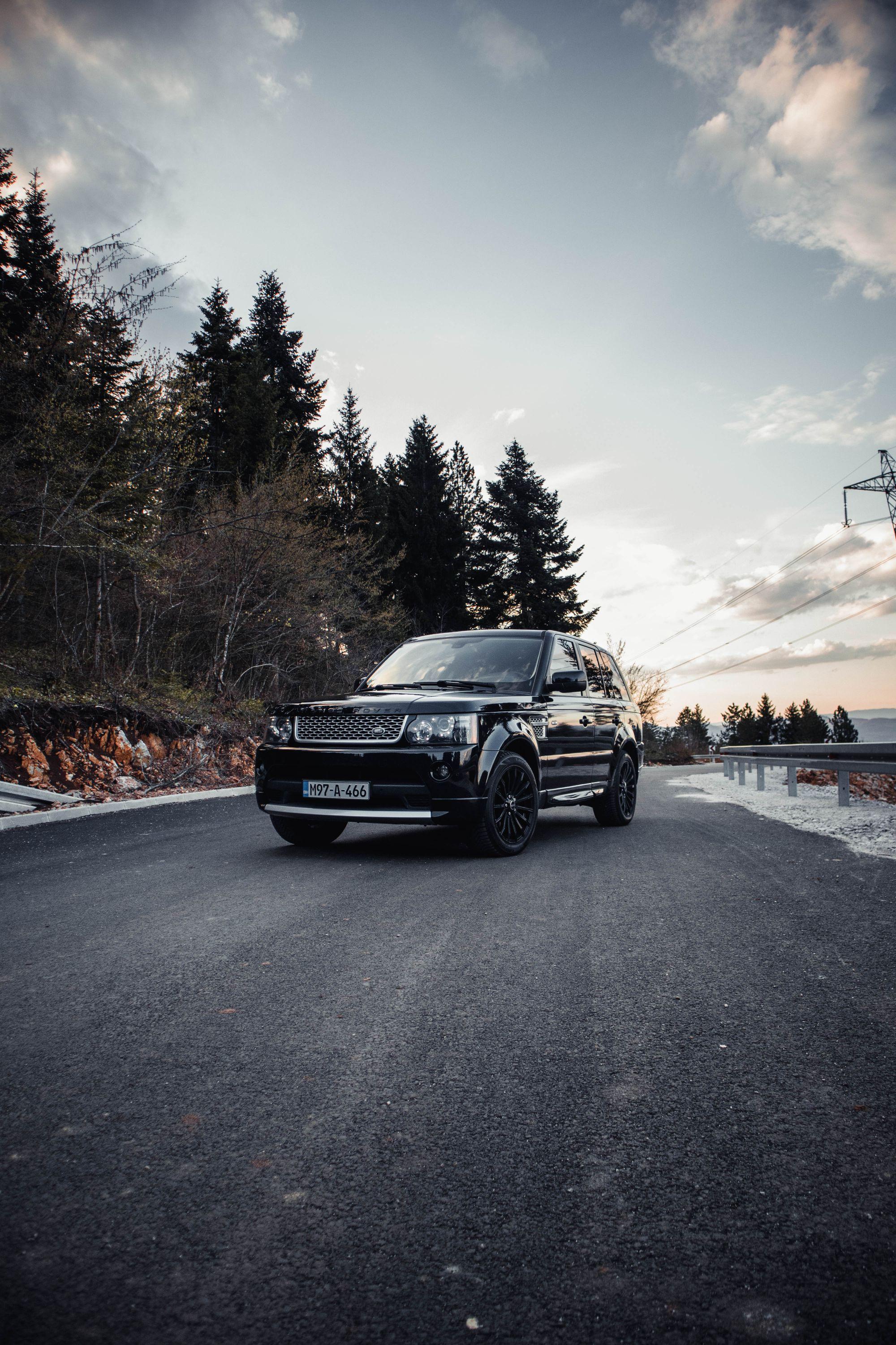 Black Range Rover on a mountain road at dusk